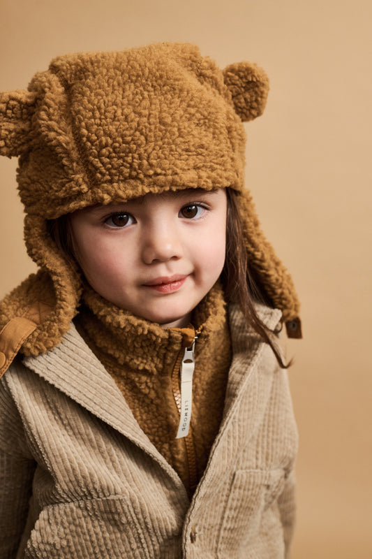 A young child wearing a beige golden caramel fleece neck warmer scarf with a half-zip detail