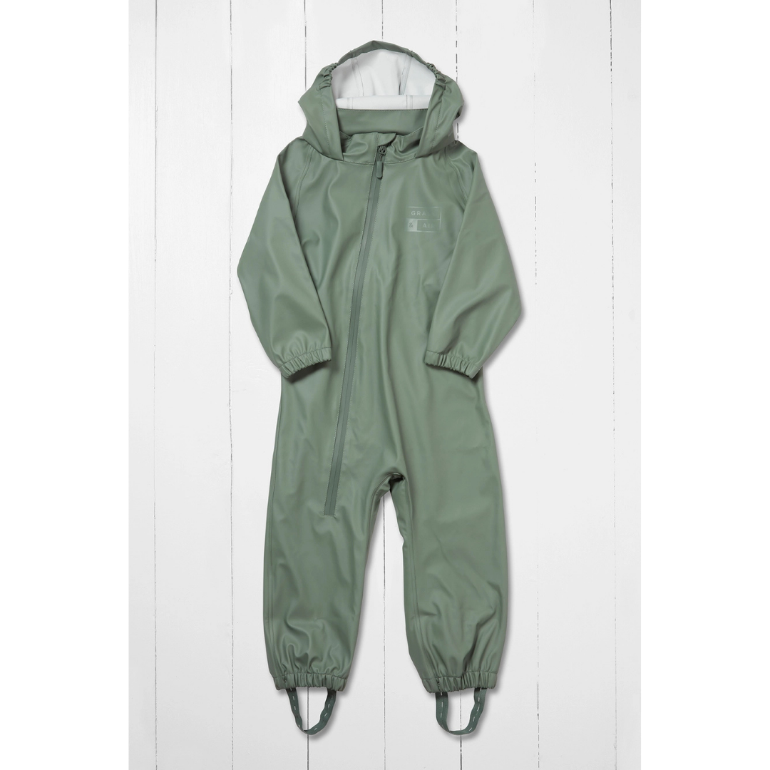 A sage green hooded one-piece hooded puddlesuit for toddlers and kids with a front zipper, elastic cuffs, and foot straps displayed flat against a white wood plank background
