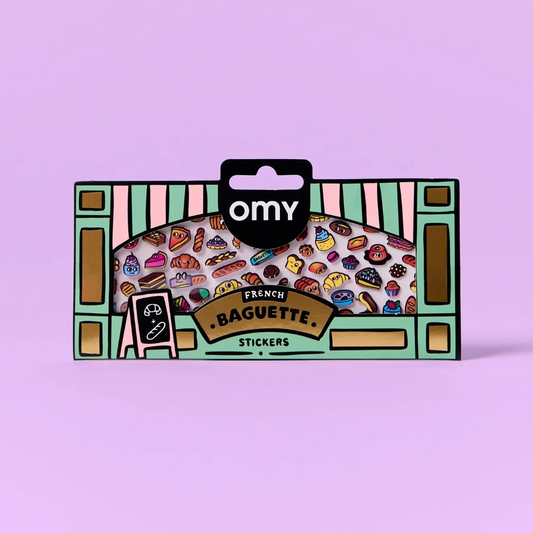 Omy French Baguette Stickers in a illustrated bakery window box packaging, featuring colorful croissants, pastries, and breads on a light purple background. Design led stationery from Paris brand OMY 