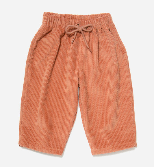 DUSTY PINK corduroy organic cotton kids trousers with a tapered leg, an elastic waistband and drawstring, laid flat on a light gray background.